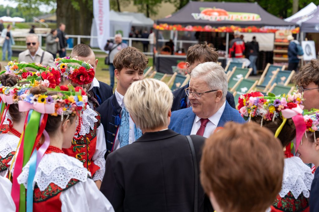 <p><span style="color: #000000;">Minister rolnictwa Czesław Siekierski rozmawia z młodymi ludźmi ubranymi w tradycyjne stroje ludowe.</span></p>
