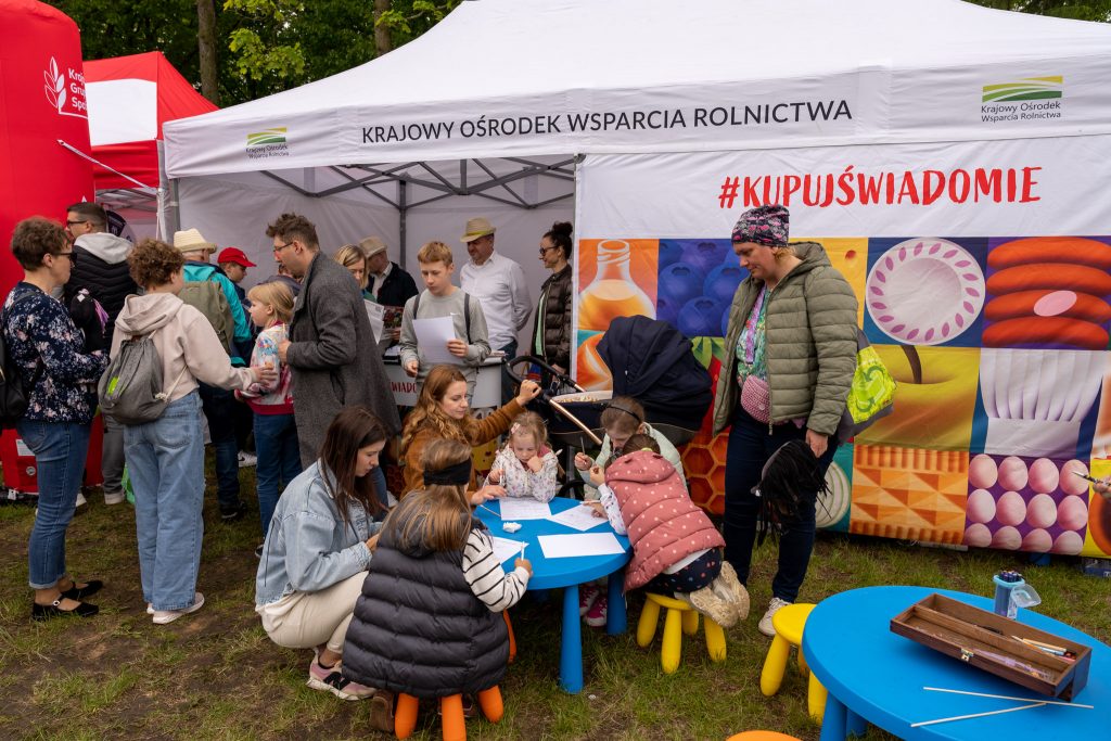 <p><span style="color: #000000;"> Rodziny z dziećmi uczestniczą w aktywnościach edukacyjnych przy stoisku #KupujŚwiadomie KOWR</span></p>