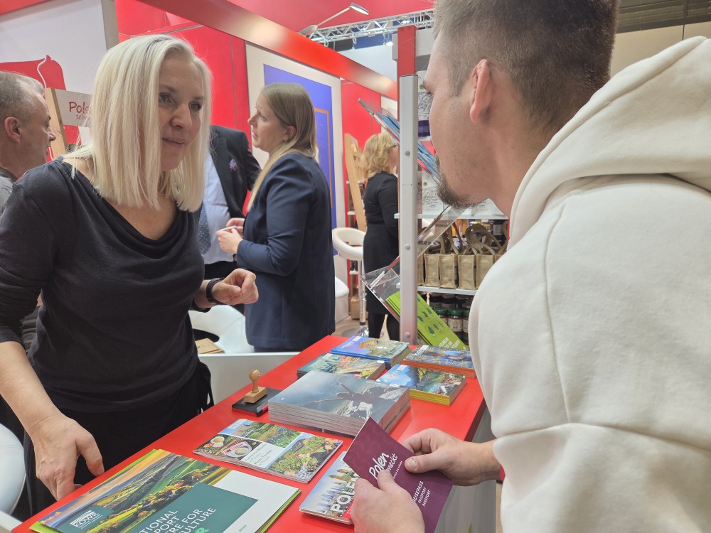 Ludzie odwiedzający targi Grüne Woche w Belinie obok polskiego stoiska informacyjnego.