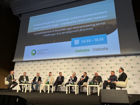 Panel dyskusyjny podczas Europejskiego Forum Rolniczego 2026 w Jasionce – dziewięciu uczestników siedzi na scenie na tle ścianki wydarzenia, biorąc udział w debacie poświęconej jakości żywności, innowacjom i przyszłości sektora rolno-spożywczego; nad sceną widoczny napis „Debata / Debate” oraz godziny sesji.