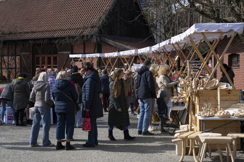 Odwiedzający spacerujący między stoiskami z rękodziełem i produktami regionalnymi podczas kiermaszu wielkanocnego #KupujŚwiadomie w Koszalinie.