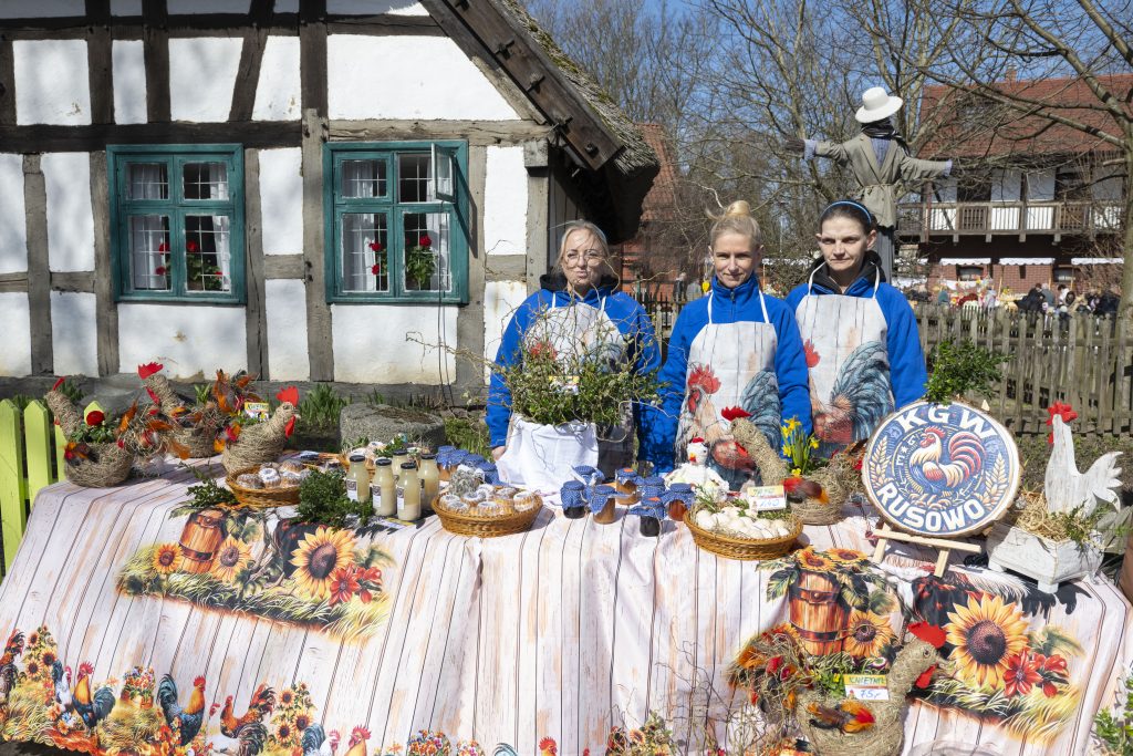 Trzy reprezentantki Koła Gospodyń Wiejskich Rusowo pozują i prezentują produkty regionalne